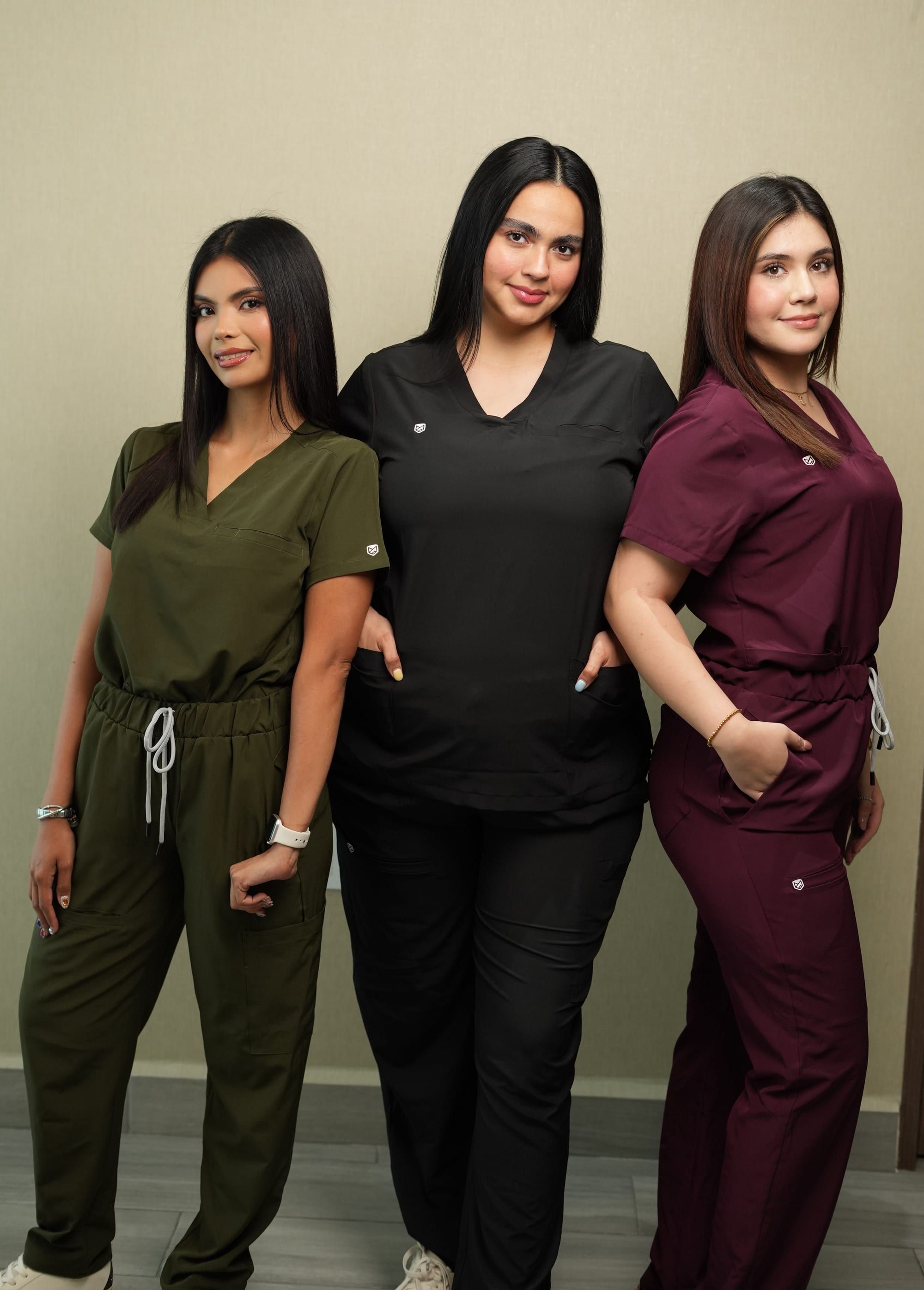 Tres mujeres con uniformes Pavés en verde olivo, negro y tinto
